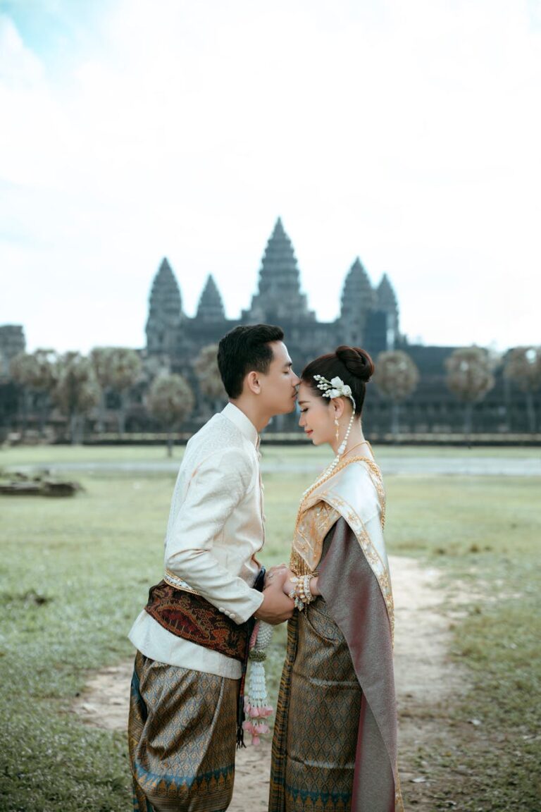 A couple in traditional Khmer clothing shares an intimate moment at Angkor Wat, Cambodia.