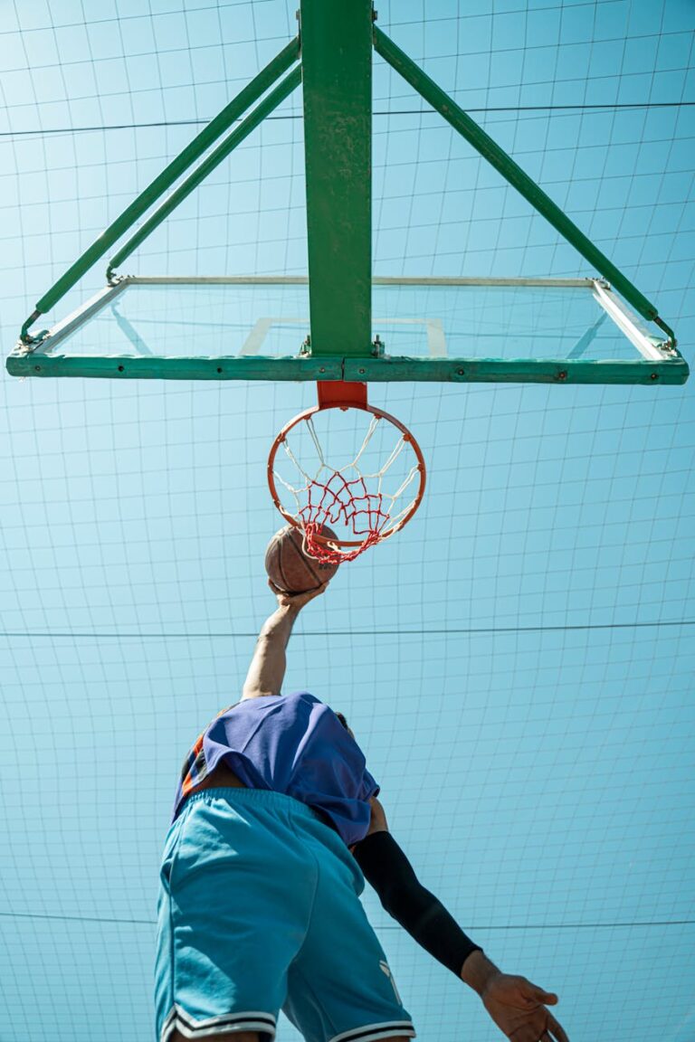 Dynamic low angle shot of a basketball player dunking outdoors in Baghdad, Iraq.