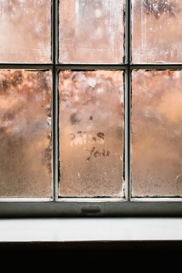 Steamy window pane with 'I miss you' message, creating a nostalgic ambiance.