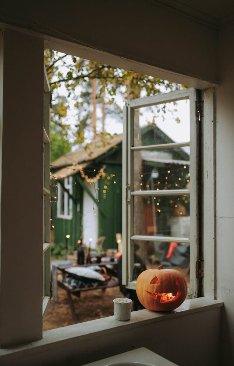 View from window of a cozy home with Halloween pumpkin and outdoor lights.
