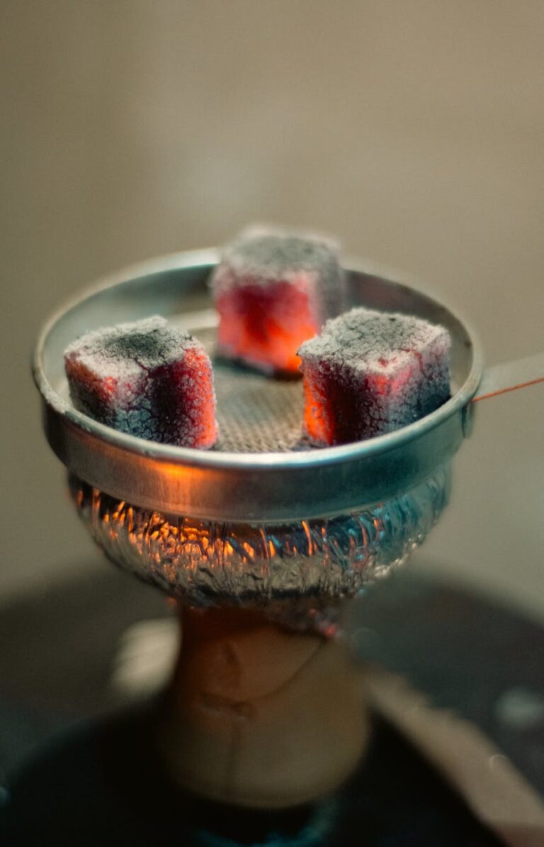 Detailed view of glowing coals on a hookah bowl, perfect for traditional smoking imagery.