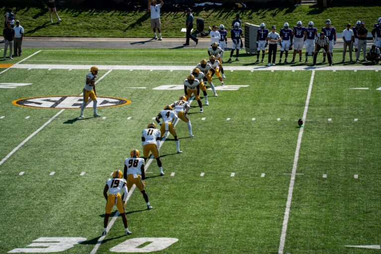 Aerial shot of an American football game kickoff with players in action.