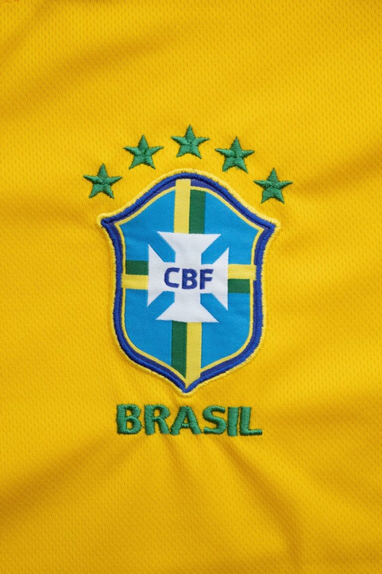 Close-up of the Brazilian football team emblem on a vibrant yellow jersey.