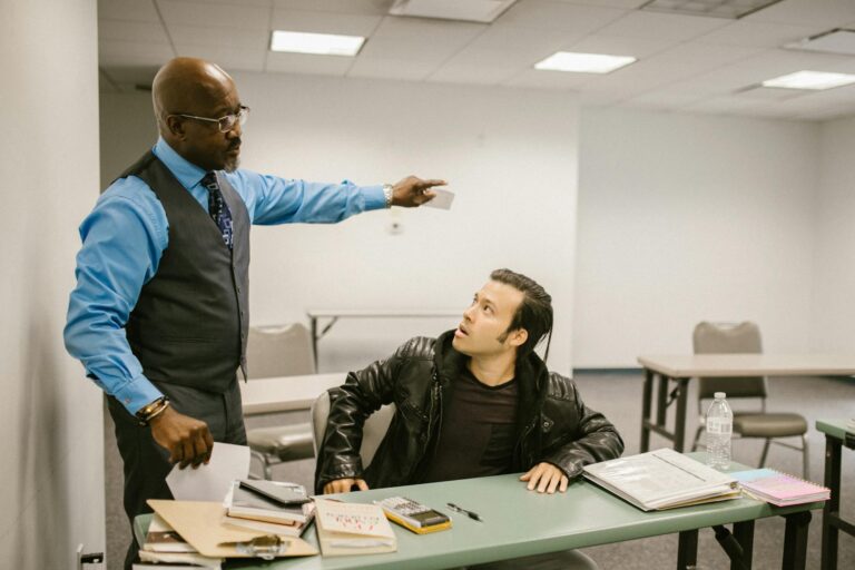 A teacher reprimands a student in a classroom, highlighting issues of academic integrity.