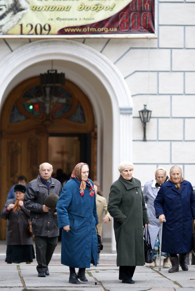 A group of elderly people leaving a church in Ukraine during the day.