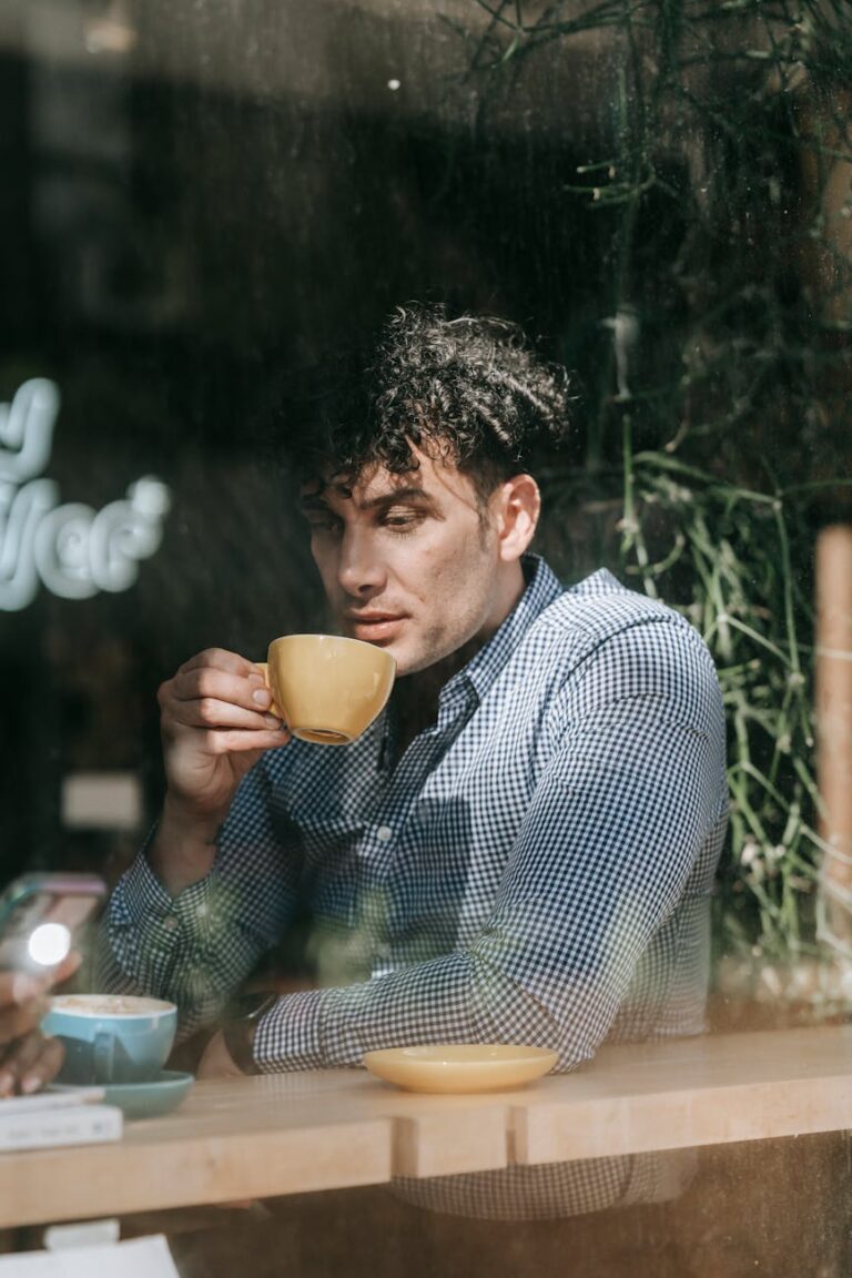 Man enjoying a coffee break in a relaxed café atmosphere, reflecting solitude and calm.