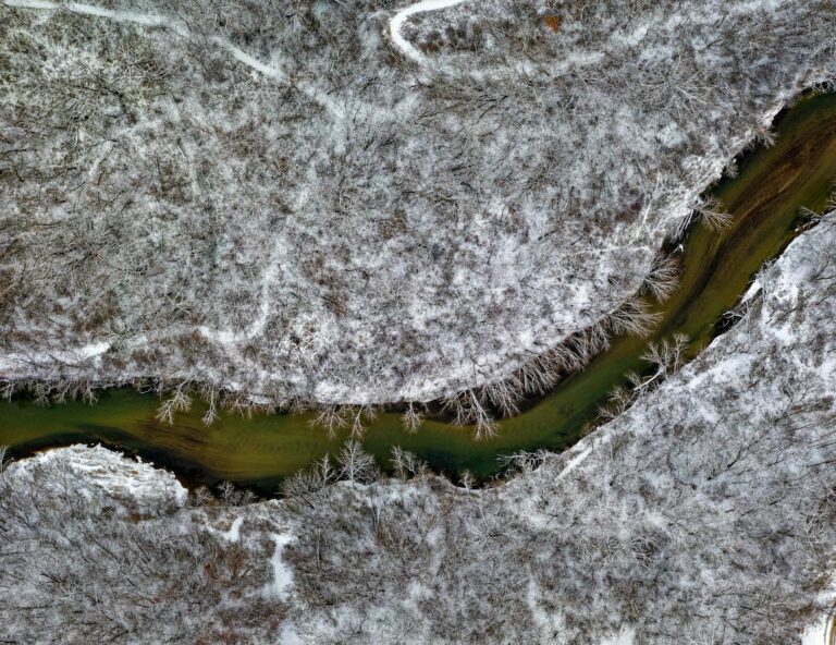 Aerial view of a snow-covered river winding through a winter landscape in Rochester, Minnesota.