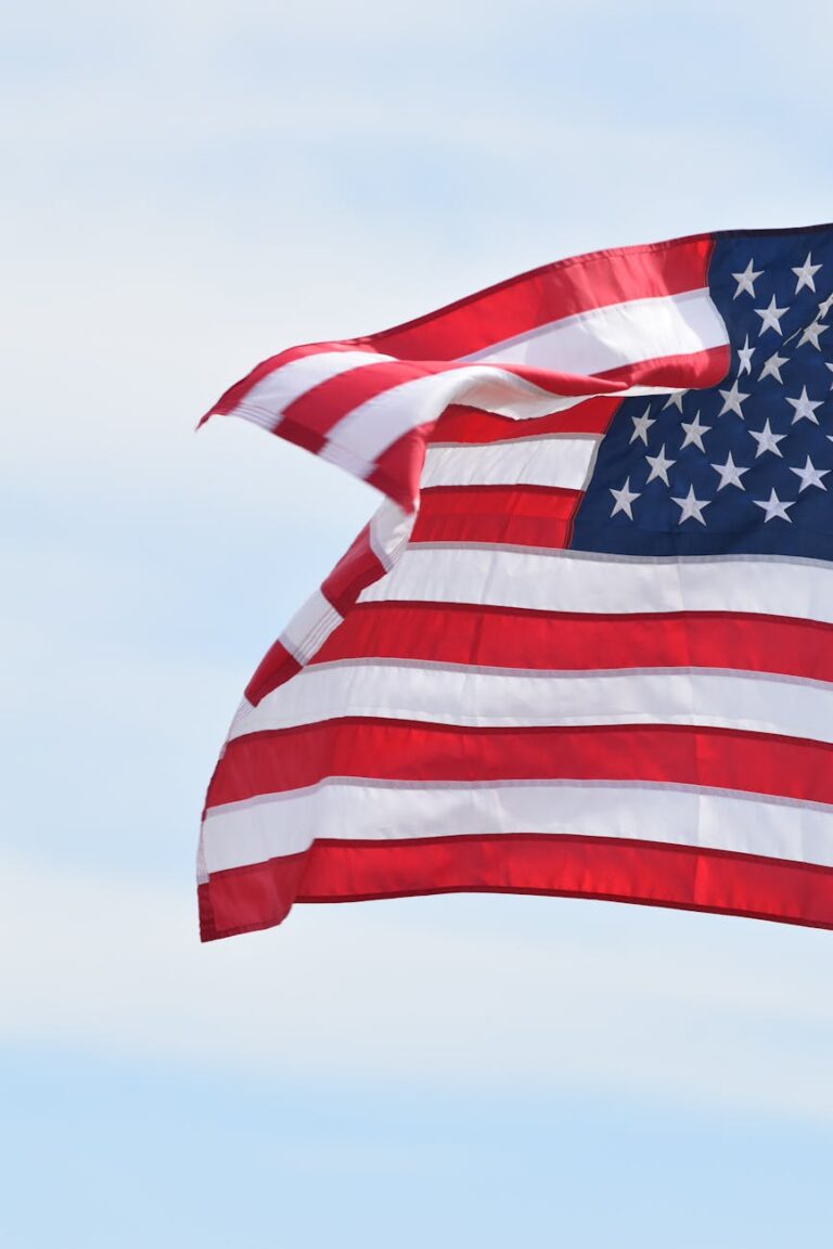 A vibrant American flag waves proudly against a bright blue sky, symbolizing national pride.