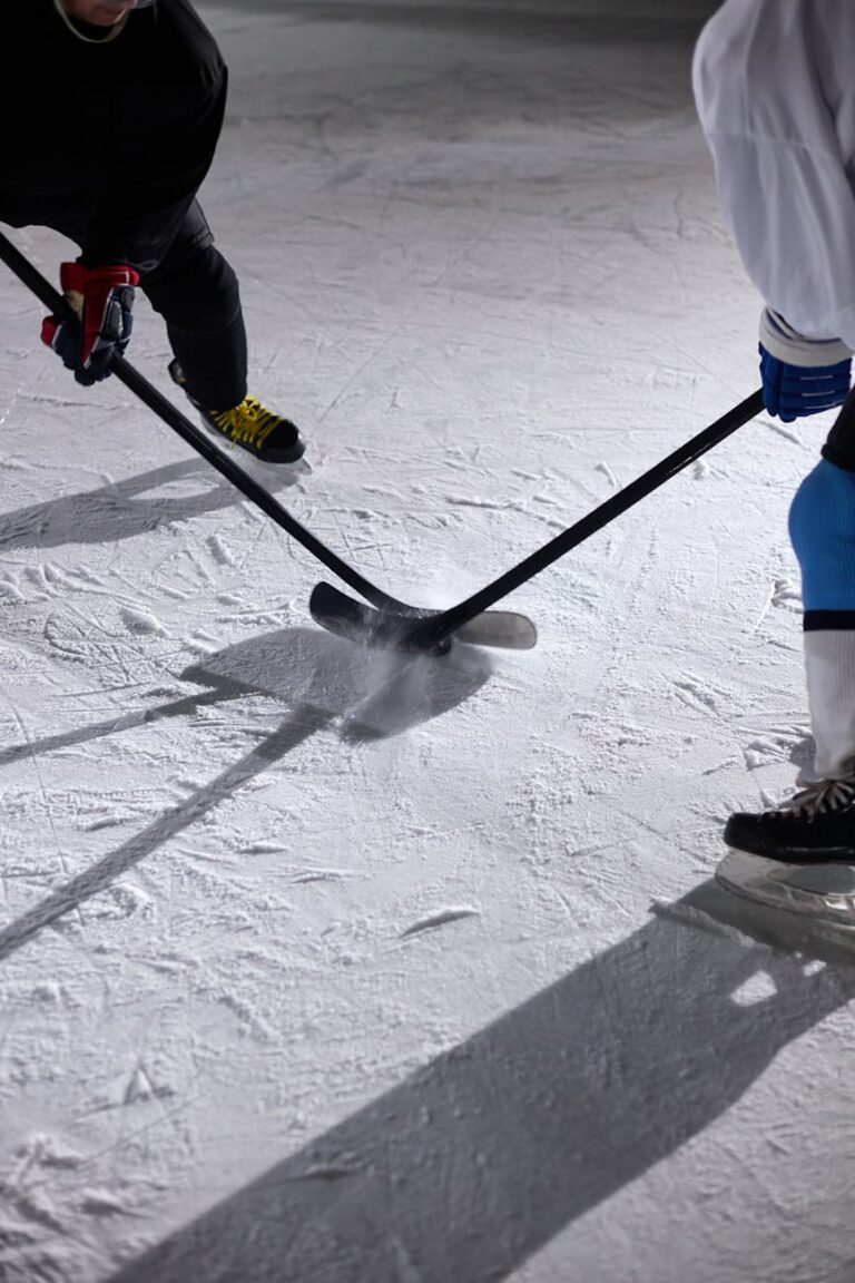 Close-up shot of hockey players battling for the puck during an ice hockey game face-off.