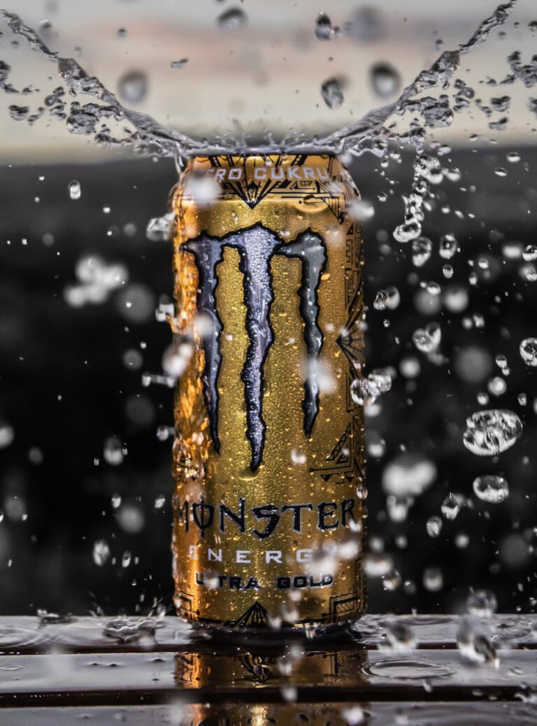 Golden energy drink can surrounded by water drops for a refreshing and dynamic feel.