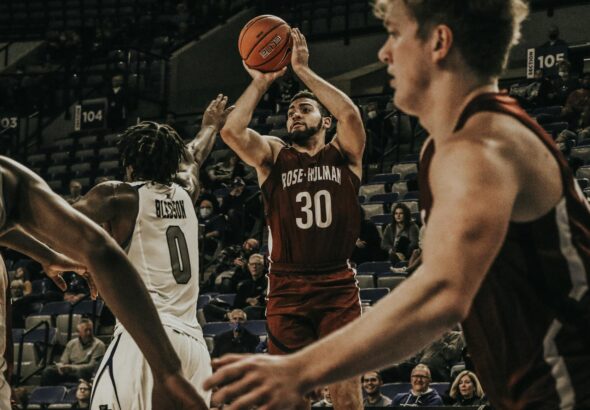 Basketball players in an intense college game action, showcasing skill on court.
