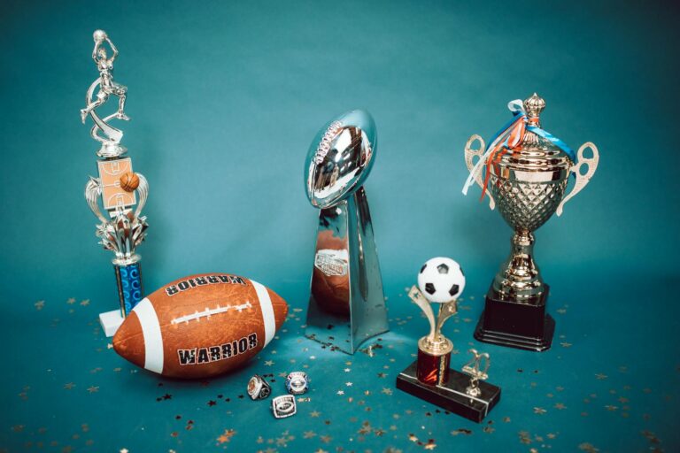A collection of sports trophies and memorabilia representing achievement and success on a blue background.