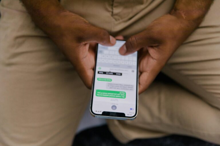 Close-up view of hands texting on a smartphone, focusing on the screen displaying messages.