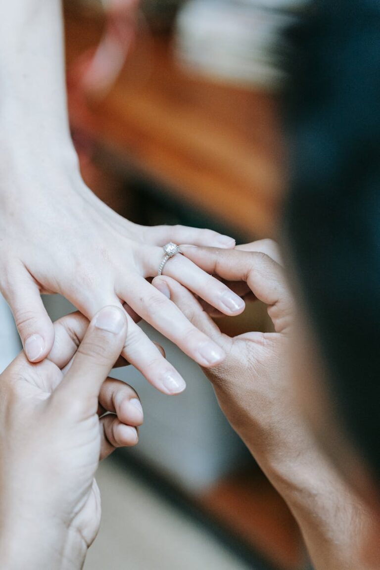 Close-up of a proposal with engagement ring being placed on a finger, symbolizing love and commitment.