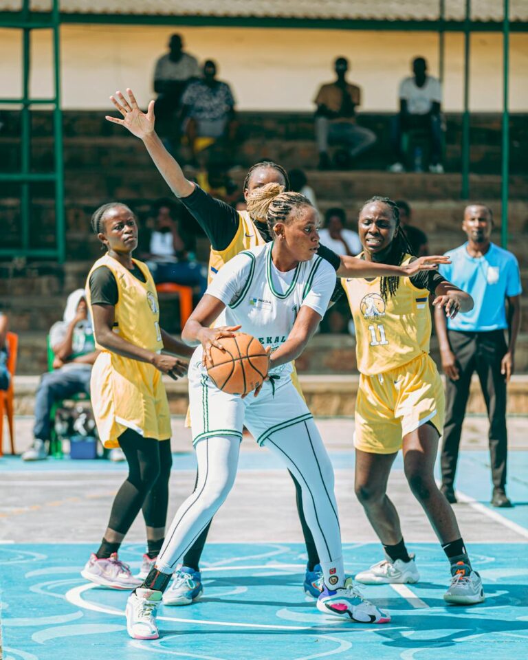 Intense action during a women's outdoor basketball match with vibrant atmosphere.