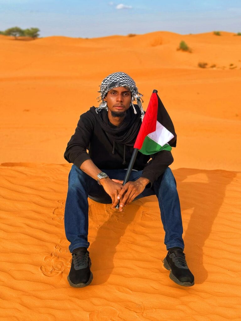 Young man holding a Palestinian flag in the Diffa desert, Niger.