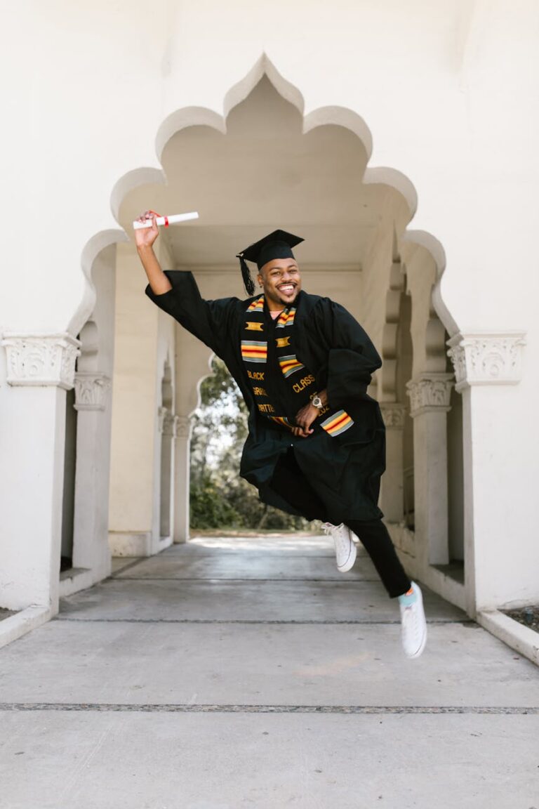 Celebrate graduation with a joyful moment captured in a white archway. An uplifting achievement scene.